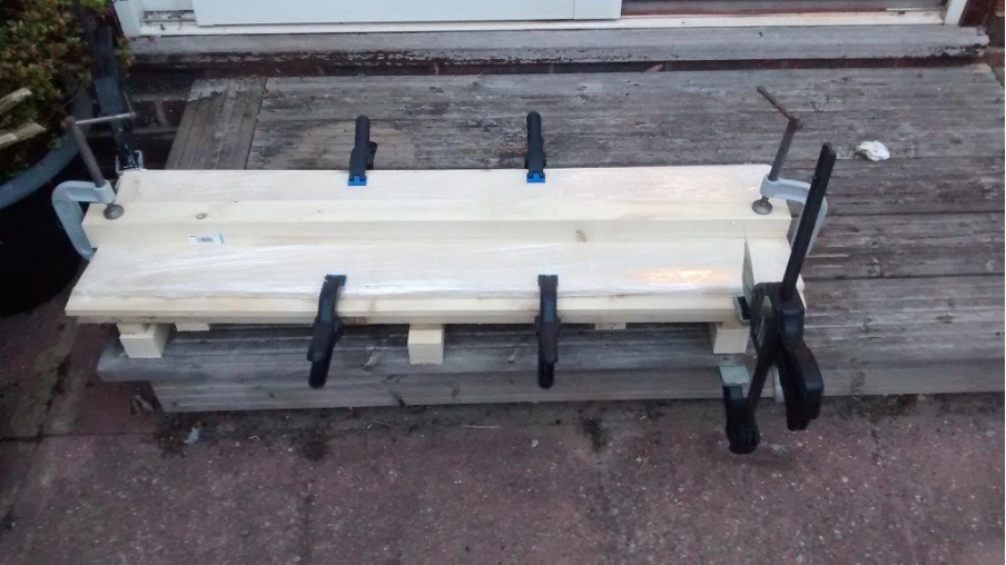 Wood glued and clamped for a longboard.